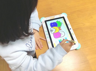 すみっコぐらしタブレットでぬりえをする子供